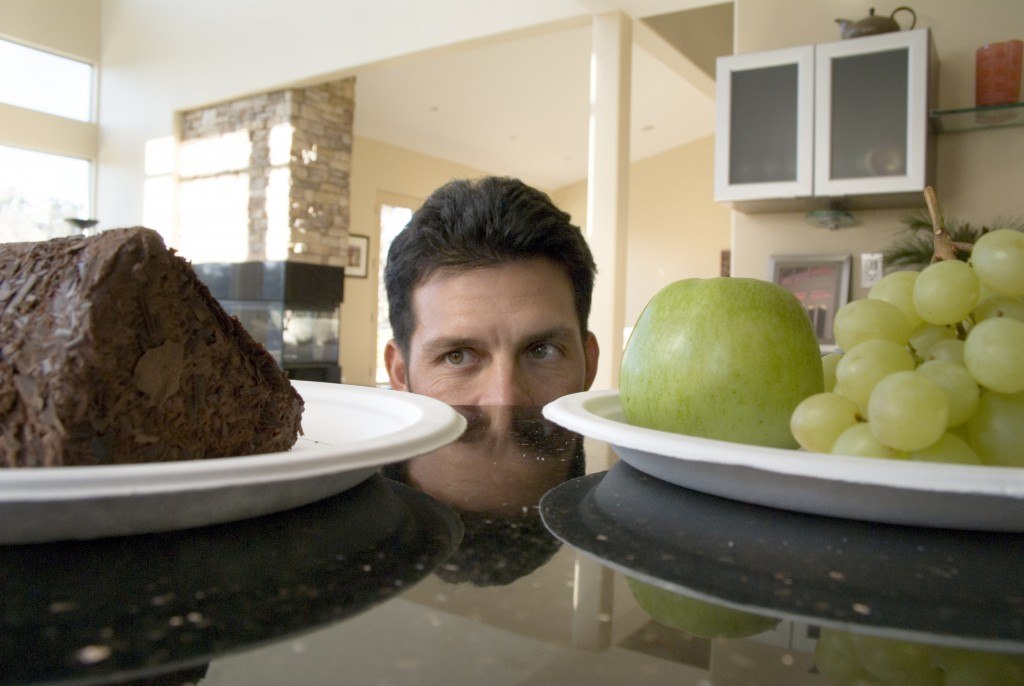 man deciding between fruit and cake