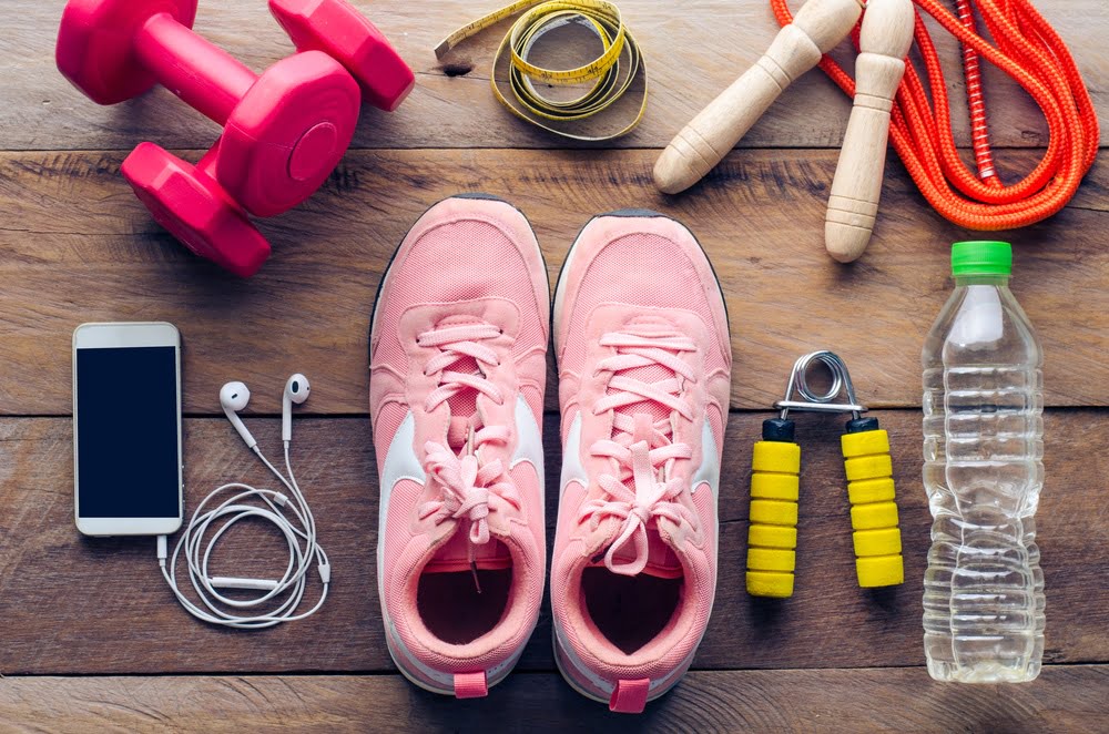 Shoes, workout equipment and water bottle on wood floor