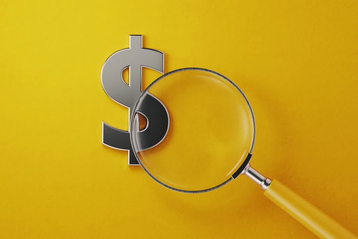 magnifying glass over a dollar sign