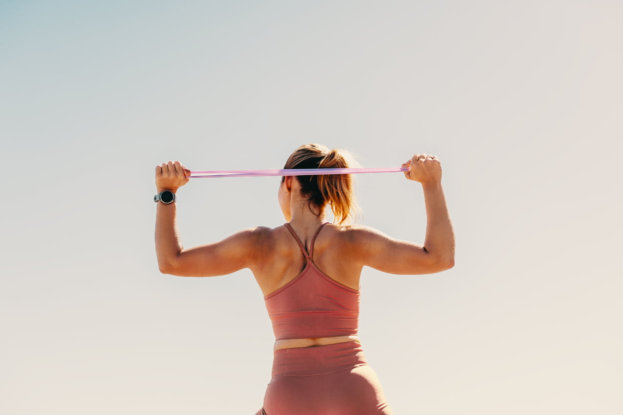 emale athlete working out with resistance bands outdoors.