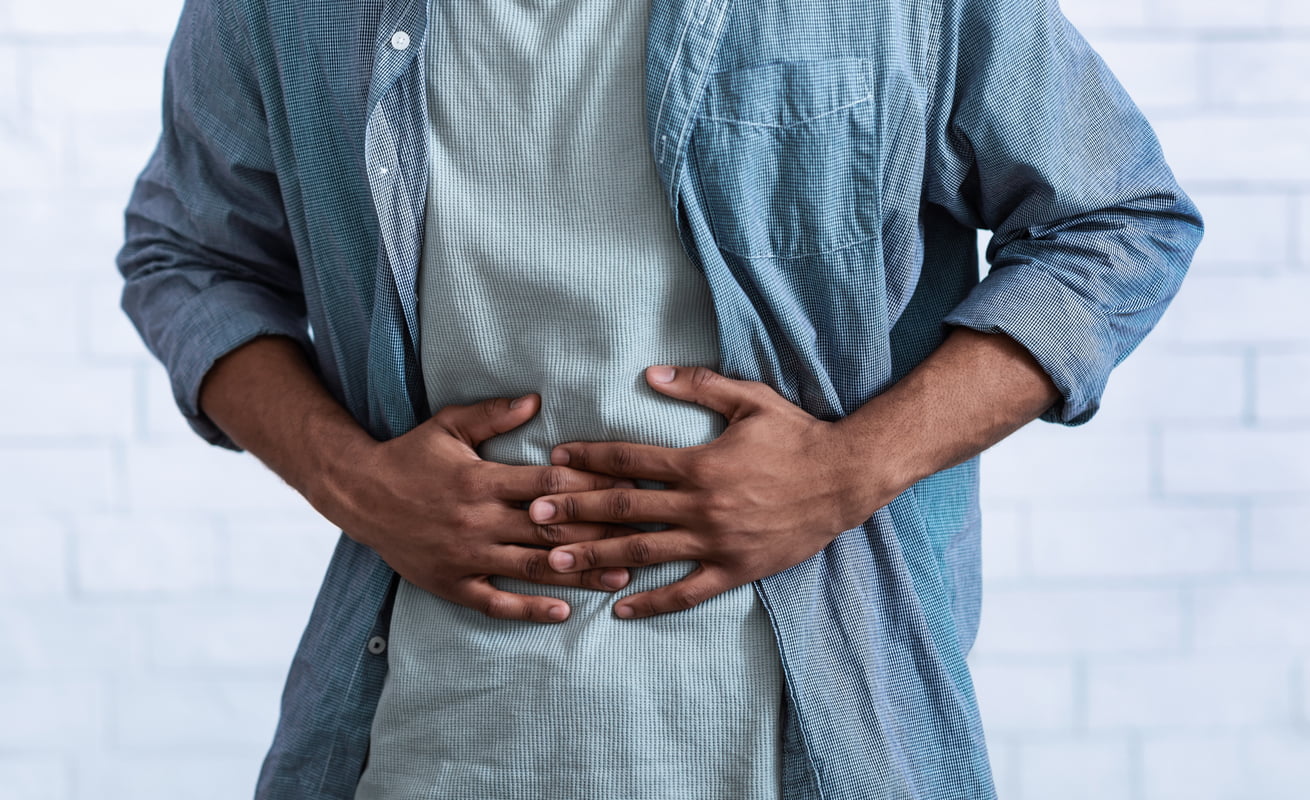 A gentleman touches in abdomen in pain