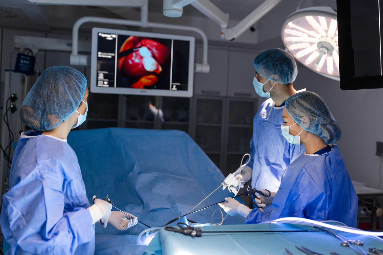 A team of doctors uses the laparoscopic surgery method to perform a procedure on a patient. 