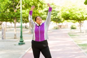 A woman celebrates achieving her fitness goals.